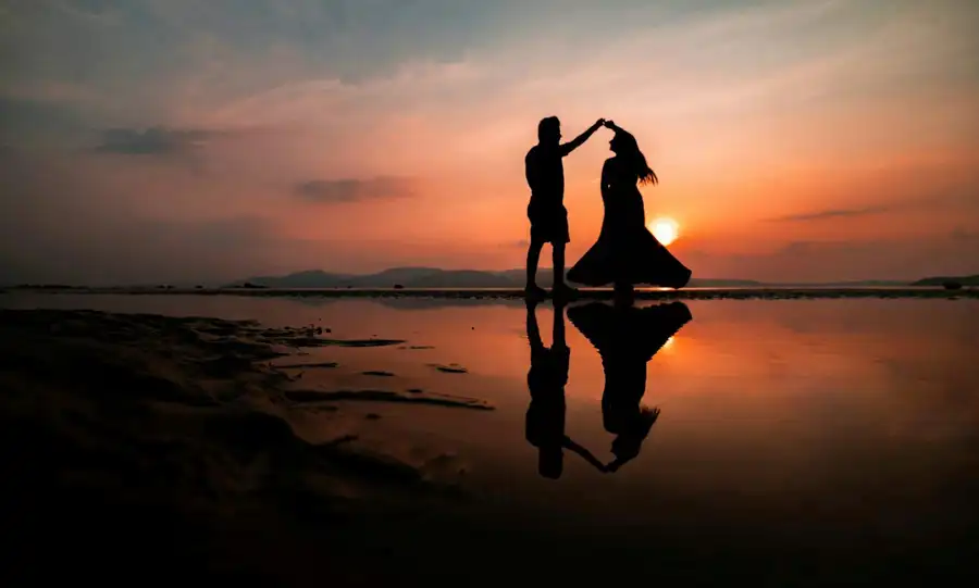 A couple by the water at sunset
